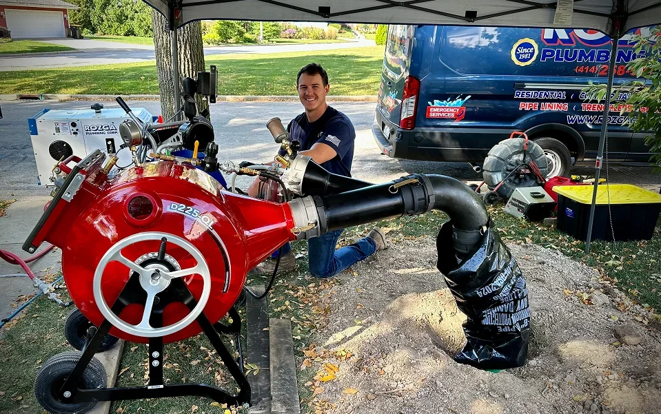 Rozga Plumbing Corp technician performing trenchless sewer lining at a residential curbside access pit in Southeastern Wisconsin